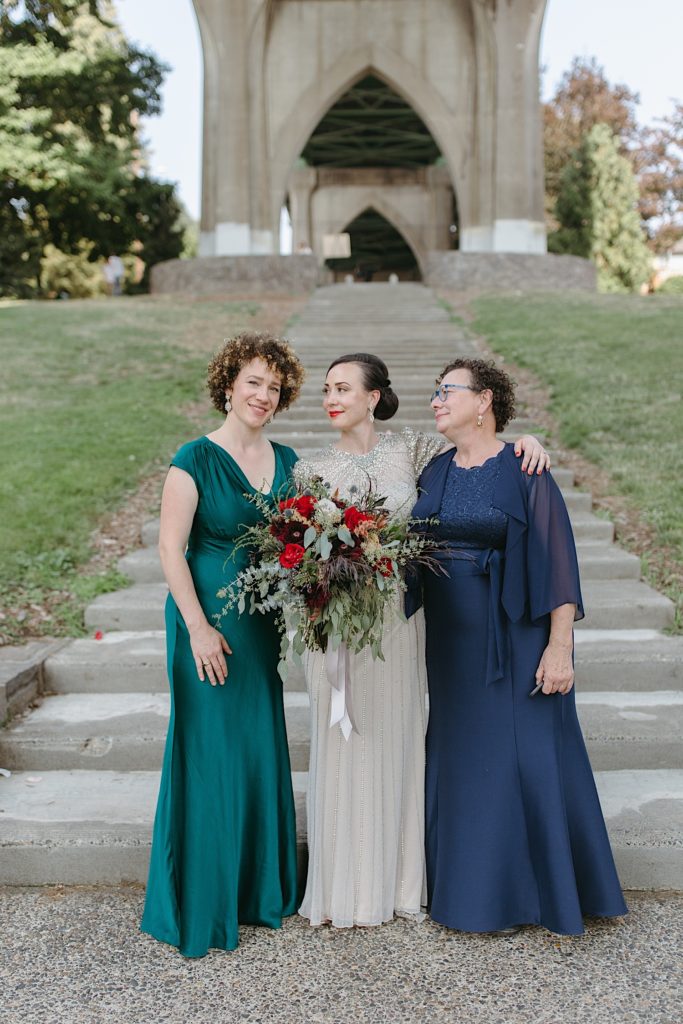 family photo of mother and sister and bride at cathedral park wedding before the ceremony