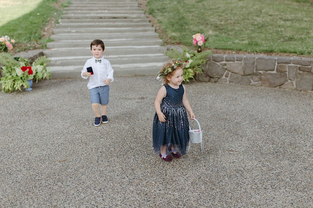 flower girl and ring bear walking down the aisle at cathedral park wedding ceremony