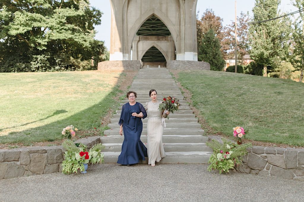 bride walking down the aisle with her mom at cathedral park wedding